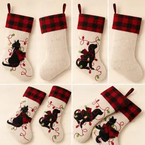Detail of embroidered pet Christmas stockings with Buffalo Plaid cuffs and LED light motifs