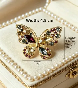Détail d'une broche papillon avec dimensions 4,8cm de large et cristaux colorés