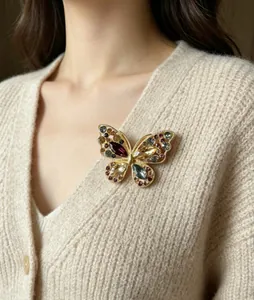 Vue détaillée d'une broche papillon en alliage avec cristaux sur un tricot