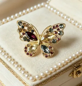 Vue détaillée d'une broche papillon plaquée or avec cristaux multicolores