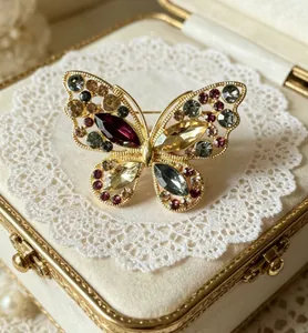 Vue détaillée de la broche papillon évidée avec strass colorés sur dentelle de velours