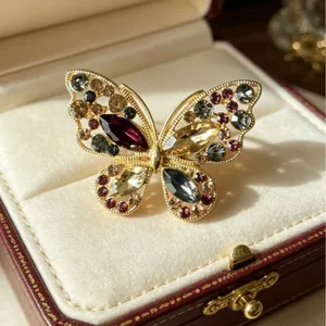 Exquise broche papillon évidée en alliage doré avec strass et gemmes colorées