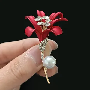 Détail d'une broche fleur rouge avec strass brillants et pendentif perle blanche