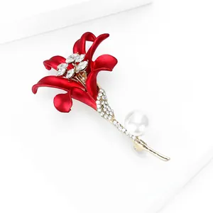 Gros plan détaillé de la broche fleur de lys rouge avec perle blanche et cristaux