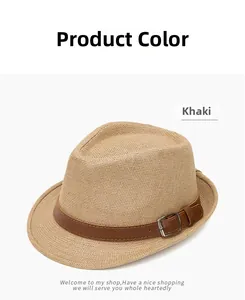 Detail of khaki straw fedora hat featuring a brown leather band and silver metal buckle