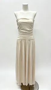 Detail of beige strapless maxi dress showing smocked bodice and pleated skirt texture