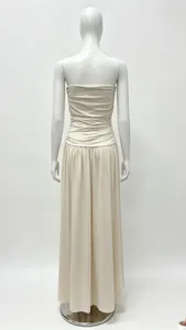Detail view of the shirred elastic back and long flowy hem of the beige maxi dress