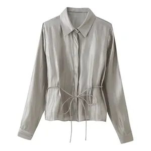 Macro view of silver-grey glossy satin shirt texture with drawstring waist detail