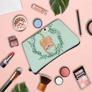Flat lay of mint green sloth cosmetic bag with makeup accessories on pink background