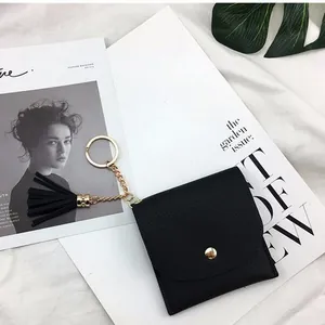 Mini black lychee leather wallet for women featuring a gold keychain and fringe tassel