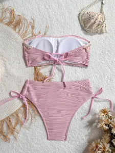 Dettaglio del bikini a fascia rosa con tessuto a onde su sfondo di peluche bianco