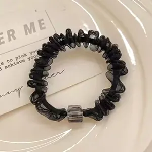 Chouchou élégant en maille noire avec un détail de perle carrée transparente