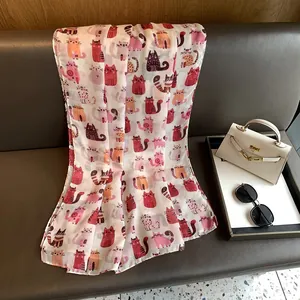 Detail view of the soft white scarf featuring colorful cartoon cat prints on leather