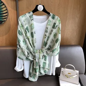 Detail of light green cotton linen scarf featuring hand-drawn cartoon cat patterns