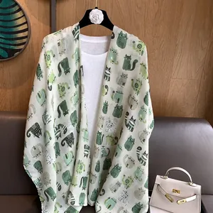 Detail of cotton linen scarf with cartoon cat patterns on a hanger with a white t-shirt