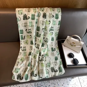 Detail of cute cartoon cat print on a cream-colored cotton linen scarf and shawl