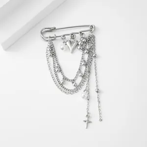 Detail of silver safety pin brooch with multi-layer chains and heart cross charms