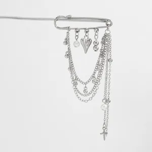 Detail of silver layered chain pin brooch with star charms and pearl accents