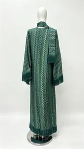 Detail of dark green V-neck dress with wave prints, tassels and matching headscarf