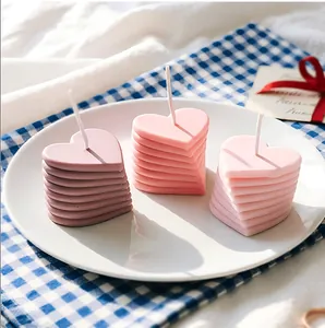 Gros plan de bougies empilées en forme de cœur dans différents tons de rose pastel