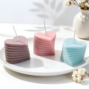 Bougies en forme de cœur empilées en violet rose et bleu sur une assiette blanche