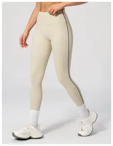 Close-up of high-waist beige yoga leggings featuring sleek black side stitching details