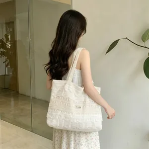 Detailed close-up of delicate white floral lace texture and fabric lining of the tote bag