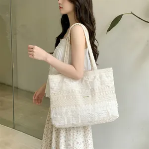 Detail of white lace crochet tote bag with tiered ruffles for summer beach vacations