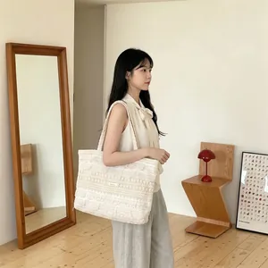 Close-up of cream lace tote bag with hollow woven textures and floral lace edges