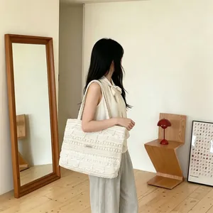 Close-up of beige crochet lace tote bag with intricate floral patterns and soft texture