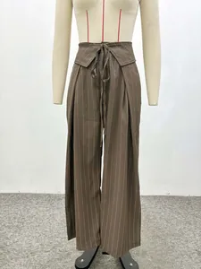 Detail of high waisted wide leg trousers with dark brown pinstripes and waist tie