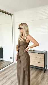 Detail of brown pinstripe vest and wide-leg trousers set with high-waist fit