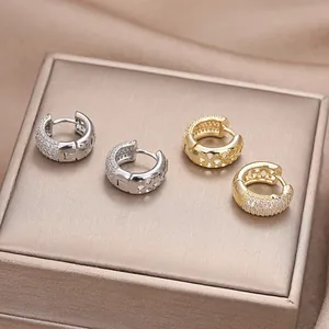 Detailansicht der Huggie-Ohrringe in Gold und Silber mit Zirkonia und Herz-Ausschnitt