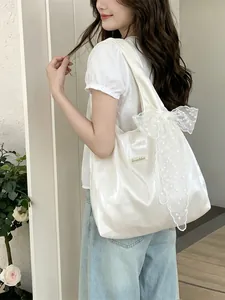 Pearlescent white tote bag with large lace bow shown on shoulder for a sweet style