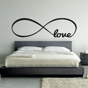 Modern black infinity love wall decal above a bed in a minimalist bedroom decor