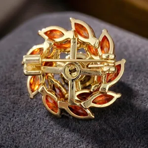 Vue arrière de la broche fleur rotative en zircon avec placage or et pierres ambre