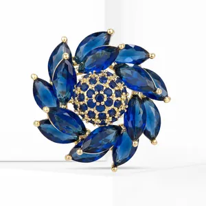 Macro de la broche fleur rotative avec pierres marquises bleues et placage en or