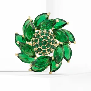 Détail macro d'une broche fleur de luxe avec cristaux vert émeraude de taille marquise