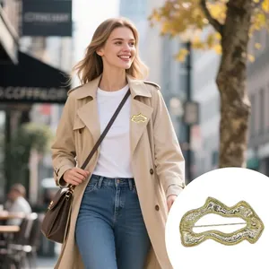 Broche géométrique chic vagues dorées avec texture métallique sur un trench-coat