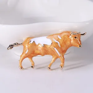 Detailed close-up of a bull brooch featuring orange enamel marble texture and gold alloy edges