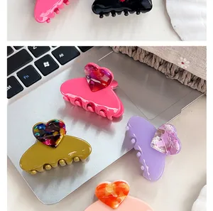 Détail de pinces à cheveux en forme de cœur avec motif marbré en plusieurs couleurs