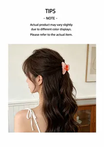 Gros plan d'une pince à cheveux rose en forme de cœur avec motifs floraux sur cheveux bruns
