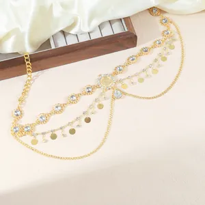 Macro detail of golden bohemian body chain with sparkling rhinestones and metal sequins