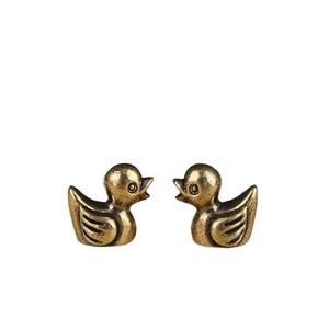 Close-up of brass bird figurines with vintage textured finish and detailed metal carving