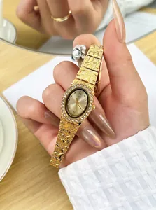 Dettaglio dell'orologio al quarzo dorato con cinturino martellato e quadrante con strass