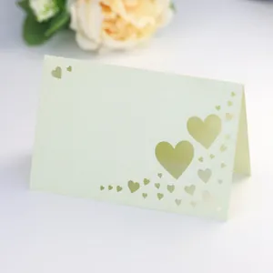 Detail of laser-cut heart hollow design on pearlescent card for wedding table seating