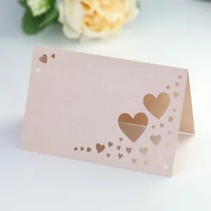 Close-up of pink glitter card with laser-cut heart patterns and pearlescent texture