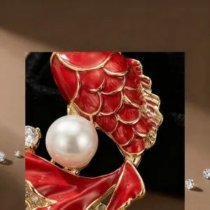 Détail macro de broche carpe avec écailles en émail rouge et grande perle blanche