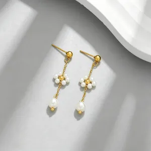 Detailed view of flower pearl drop earrings with gold chain and teardrop pearls