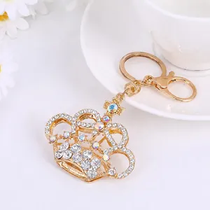 Detail of a sparkling golden crown keychain featuring crystals and elegant metal plating